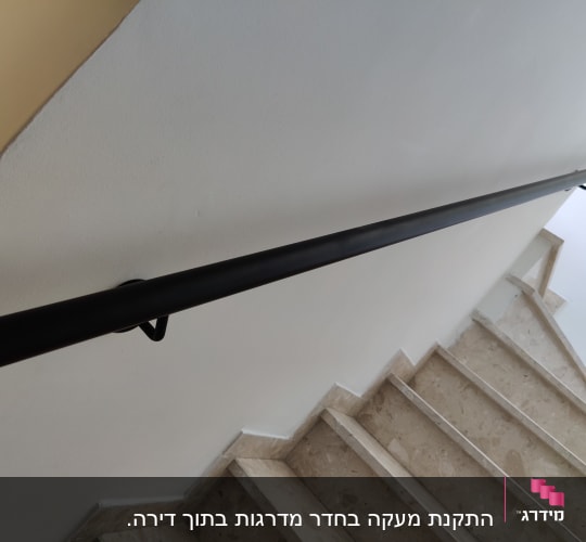 מעקה שחור מותקן לאורך גרם מדרגות פנימי